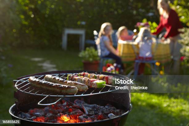 Barbecue Grill On A Summer Evening With Family In Background Stock Photo - Download Image Now