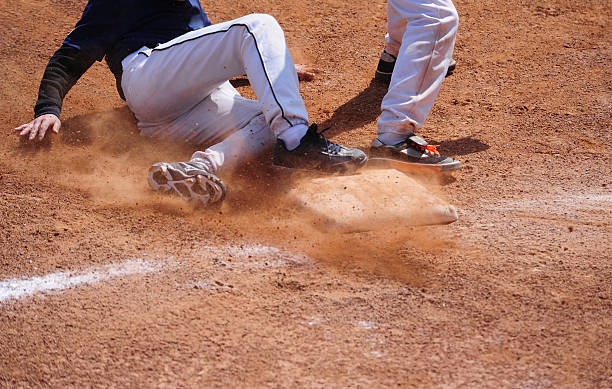 giocatore di baseball esecuzione scivolare in base - baseball shoe foto e immagini stock