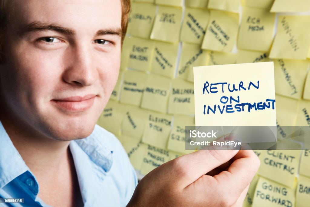 Sonriente joven hombre con retorno de la inversión Nota - Foto de stock de Llegada libre de derechos