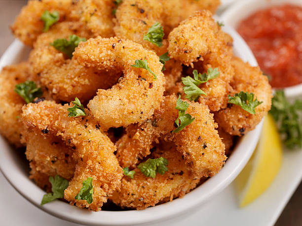 PopCorn Shrimp PopCorn Shrimp with fresh Parsley, Lemon and Cocktail Sauce - Photographed on Hasselblad H3D2-39mb Camera breaded photos stock pictures, royalty-free photos & images