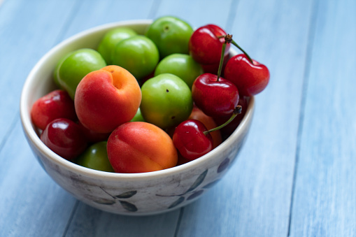 Bowl of healthy fresh fruit on wooden background