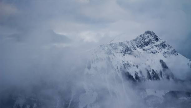 istock Scenic view of a mountain range covered with snow and clouds 1658578290