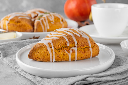 Traditional pumpkin scones with cinnamon, anise and sugar glaze on top. Autumn dessert