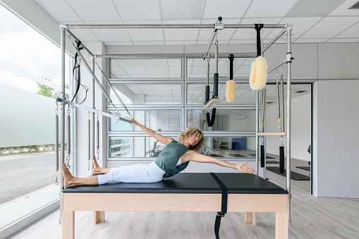 Pilates studio gym: Instructor on trapeze table
