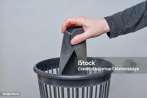 istock Person Disposes a Worn Mouse Pad into a Trash Bin 1658619676