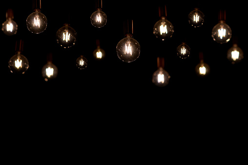 Loft-style retro lamps on a black background, copy space.