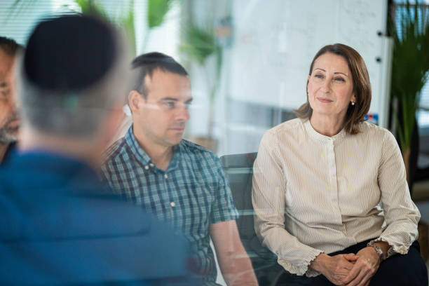 Mature Jewish market agent leading group training session.