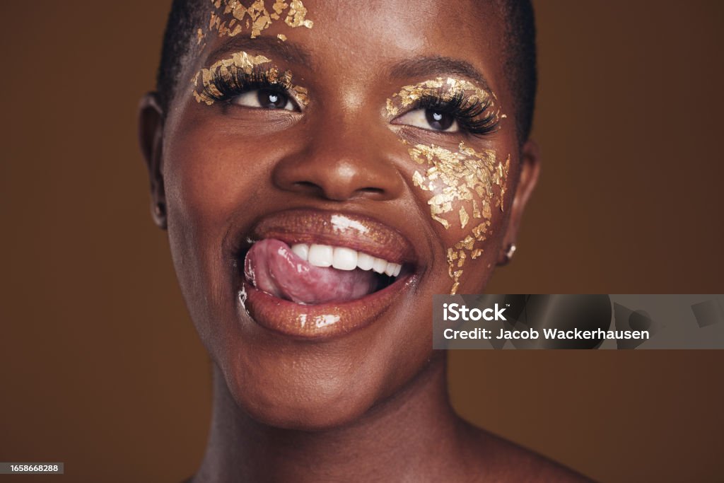 Gold Glitter And Black Woman Beauty With Makeup And Tongue Out In Studio  With Sparkle Cosmetics Brown Background Funny And Female Model With Golden  Paint For Skin Glow And Creative Facial Shine