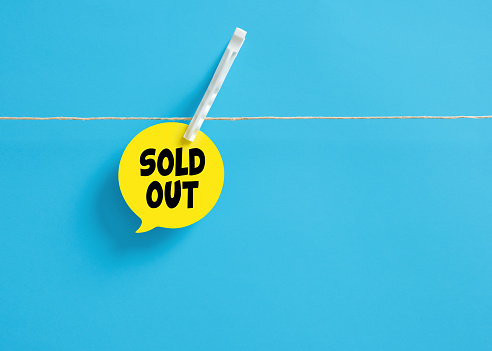 Sold out message on a speech bubble hanging on clothesline with a clothespin. Business sales concept.