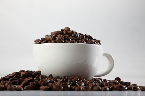 cup full of coffee bean on the plain background