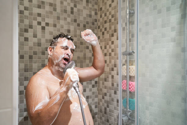 man singing in the shower stock photo