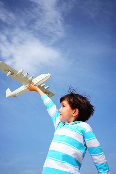 istock Cheerful boy playing with toy aeroplane 165874162