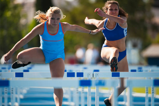 em obstáculo de corrida de atletas do sexo feminino - hurdling hurdle running track event imagens e fotografias de stock