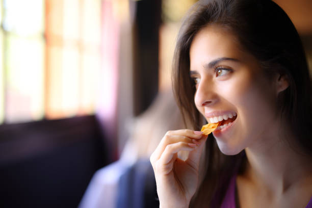 istock Happy restaurant customer eats chips and looks away 1658750242