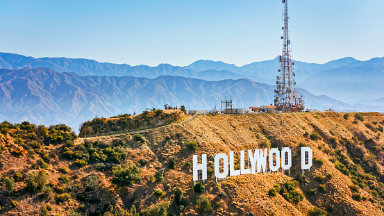 City Of Los Angeles, CA / USA - July 27, 2022: Aerial view of Hollywood sign on Mount Lee against mountain range, Hollywood, City Of Los Angeles, California, USA.\n\nThe Hollywood Sign is an American landmark and cultural icon overlooking Hollywood, Los Angeles, California.