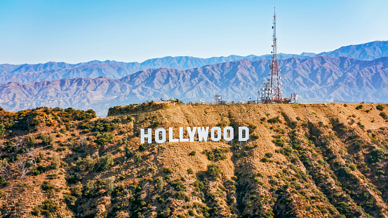 City Of Los Angeles, CA / USA - July 27, 2022: Aerial view of Hollywood sign on Mount Lee against mountain range, Hollywood, City Of Los Angeles, California, USA.\n\nThe Hollywood Sign is an American landmark and cultural icon overlooking Hollywood, Los Angeles, California.