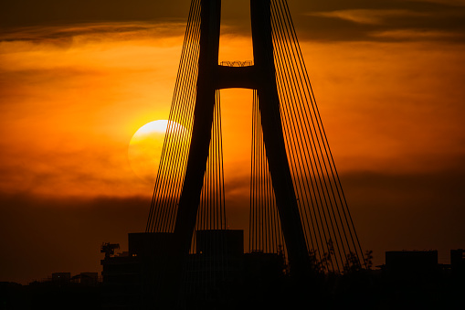 The sunset and the silhouette of the bridge piers. Zhongxing Bridge spans the Tamsui River and connects two cities. Taipei City.