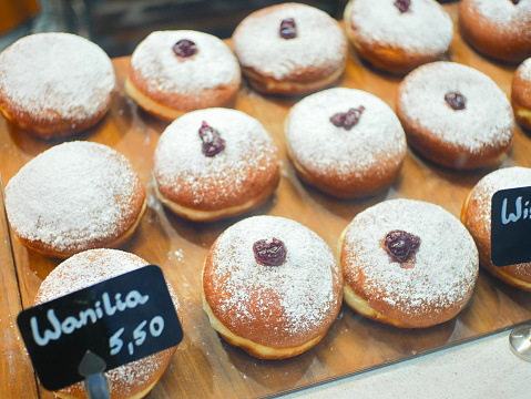 Vanilla paczek (polish donut) sprinkled with powdered sugar on a stall