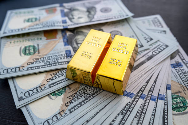 istock 100 dollar bill with gold bars as finance background 1658792107