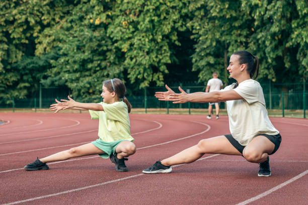istock Mother and little daughter are doing exercise in the stadium. 1658792128