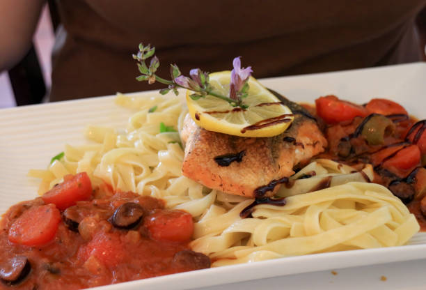 Tagliatelle pasta with grilled salmon and a tomato vegetable sauce