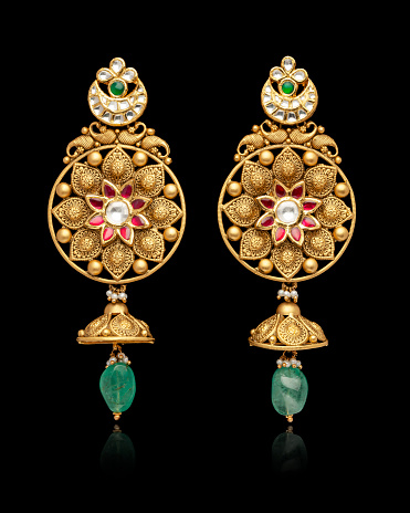 Pair of designer Earrings with gemstones and diamonds isolated over a black background. Front view.