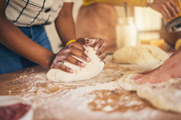 istock Bakery, hands and baking by people or chef on a kitchen table cooking bread, pizza or pastry with dough. Culinary, counter and person preparing food at a restaurant with ingredient or recipe 1658803781