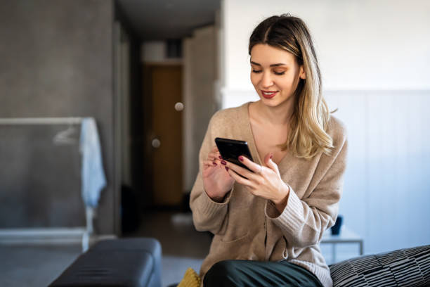 istock Smiling young woman chatting in social networks, working, using mobile applications at home. 1658814220