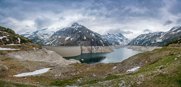 Wide view of ripples in an alpine lake with trees and mountains in the background.