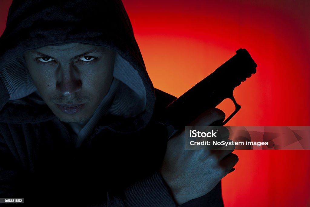 Homme à capuche avec revolver - Photo de Arme à feu libre de droits