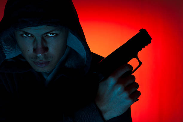 istock Man in hood with revolver 165881852