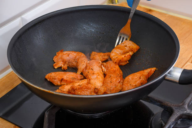 Raw pieces of meat fried in a pan in the kitchen closeup