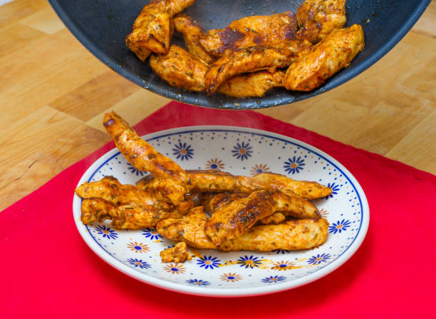 istock Fried chicken poured from the pan onto a plate 1658826358