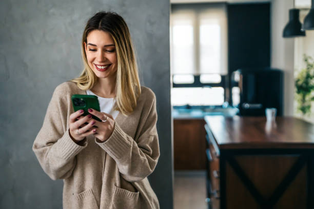 istock Smiling young female using mobile phone app playing game, shopping online, ordering delivery 1658830696