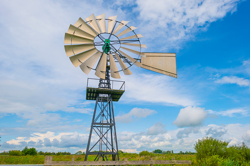 Wind motor in wetland in sunlight in summer, De Alde Feanen, Earnewald, Friesland, Netherlands, August, 2023\nwindmill, wind motor, rose
