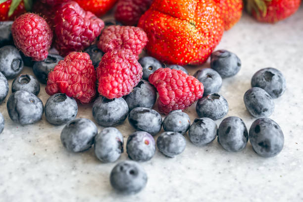 istock Blueberries, raspberries and strawberries on the kitchen table, close-up. 1658835638