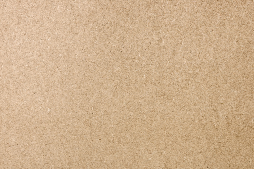 Simple full frame background close-up of a flat cardboard surface.