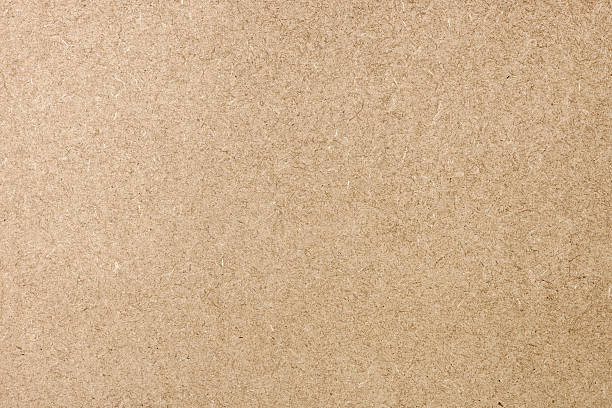 Flat Cardboard Background Texture Simple full frame background close-up of a flat cardboard surface. pressboard stock pictures, royalty-free photos & images
