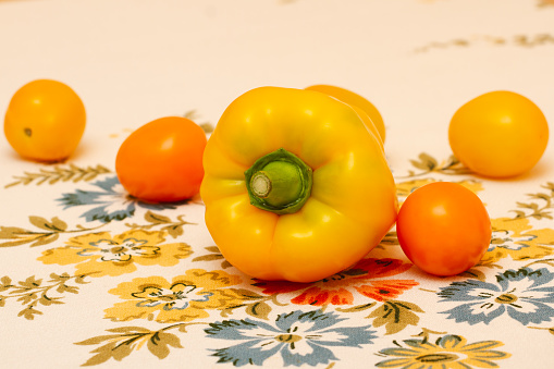 Желтый болгарский перец с золотыми помидорами крупным планом. Здоровое питание.
