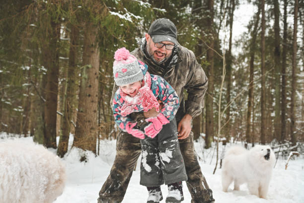 istock dad and daughter walk in the winter forest 1658851654