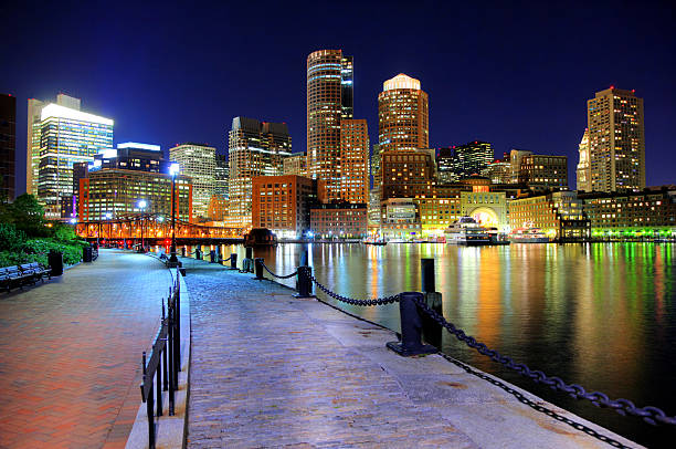 vista nocturna de boston desde el riverwalk - boston harbor fotografías e imágenes de stock