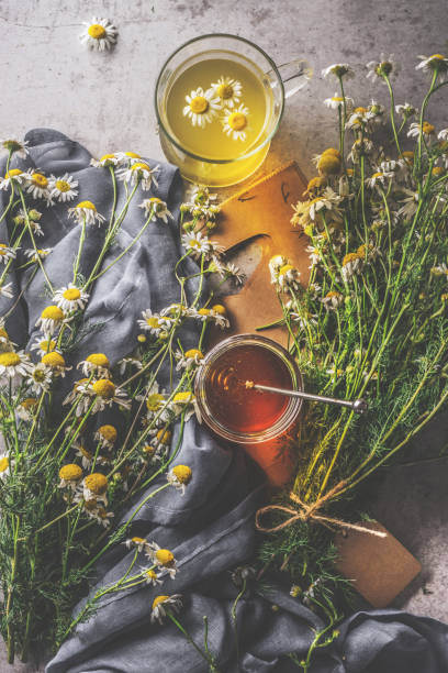istock Herbal tea in glass cup on rustic table with with honey and  fresh chamomile 1658857595
