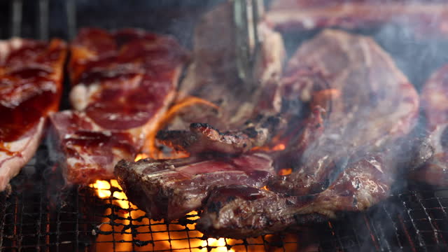 Close up meat cooking on a smoky barbecue outdoors is a classic and mouthwatering scene