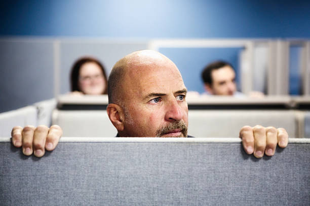 Cubicle Curiosity Three office worker look over their cubicle to the right with concern. office cubicle photos stock pictures, royalty-free photos & images