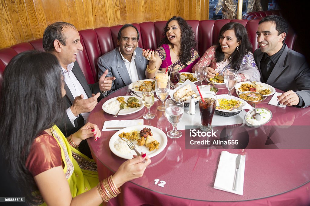 Happy group of adult friends at an indian restaurant Happy group of dressed-up indian friends at an indian restaurant. You might also be interested in these: Restaurant Stock Photo