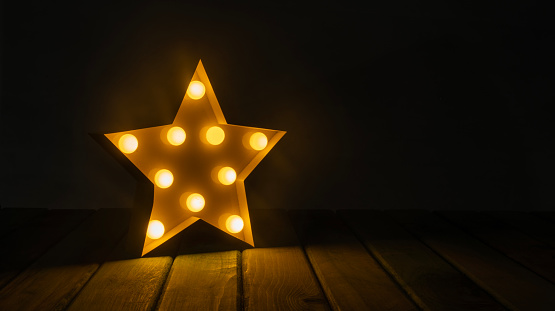 Star lamp lights on vintage wood background - celebration theme.