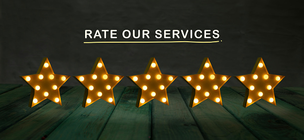 Rate our services concept with star lamps light 5 stars.