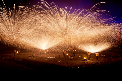 One of the traditional folk performances in Henan Province, China during the celebration of Chinese New Year，The iron flower is a large-scale traditional folk firework. It is a folk cultural performance technique discovered by ancient Chinese craftsmen in the process of casting utensils. The iron flower in Kaifeng, Henan, China is also known as the top ten folk arts in the Yellow River Basin, with more than ten Performers take turns using flower sticks to hit molten iron with a temperature of more than a thousand degrees into the sky, forming steel fireworks more than ten meters high. The scene is spectacular, showing thrilling, festive and lively characteristics.