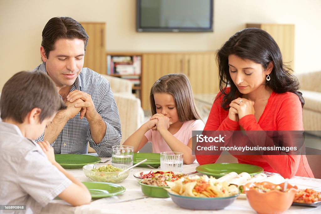 Giovane ispanica famiglia dicendo le suppliche prima pasto a casa - Foto stock royalty-free di Pregare
