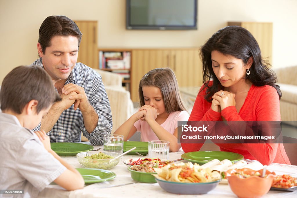 若いヒスパニック系家族の前で祈ること自宅でのお食事 - 祈るのロイヤリティフリーストックフォト